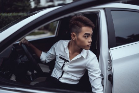 Junger Fahrschüler sitzt im Auto