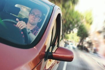 Junger Mann steuert Auto